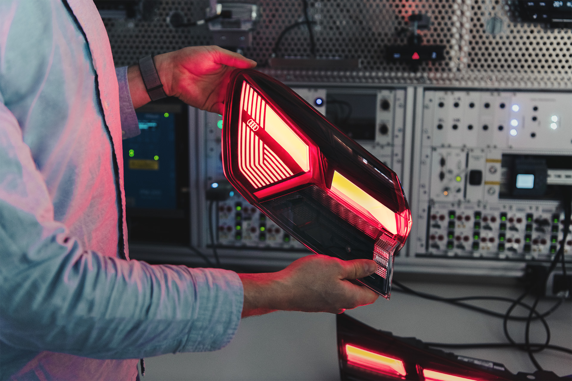 An Audi engineer holding a section of the Audi Q4 e-tron rear light.